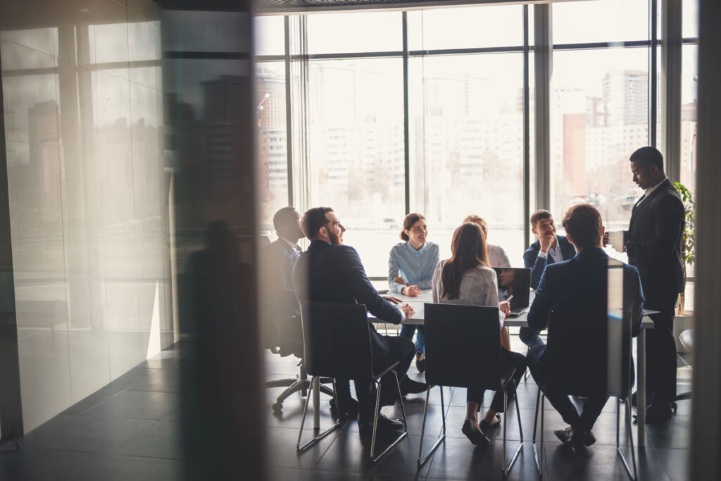 people sitting at table in conference room listening to presentation