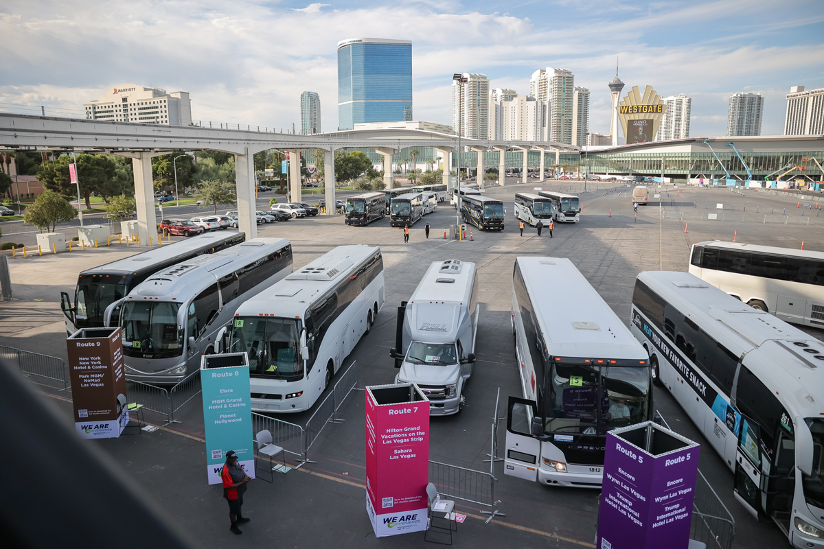 overview shot of shuttle busses in parking lot and skyline in the background