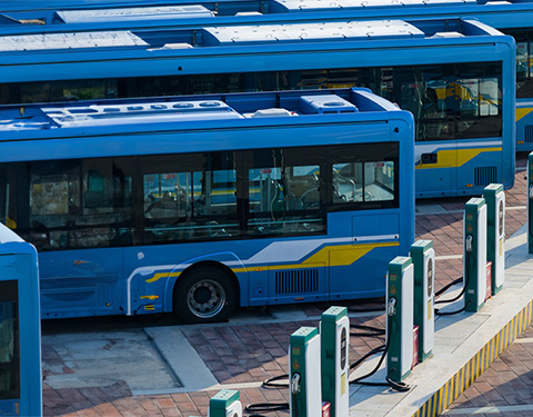 electric busses lined up in front of charging station